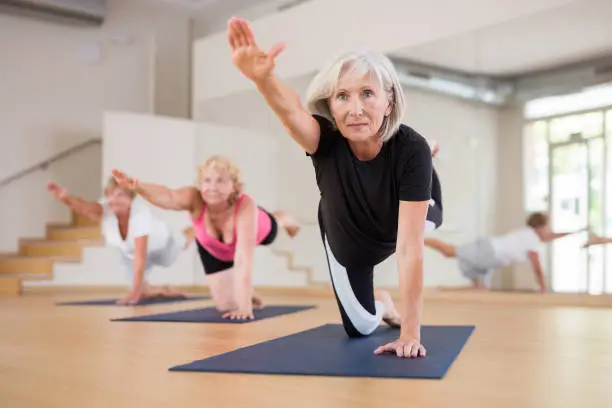 An elderly lady demonstrating the balancing table pose